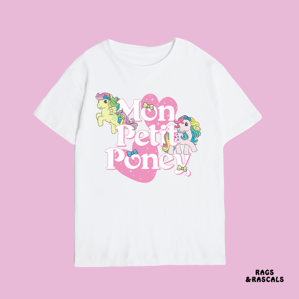 White t-shirt with 'Mon Petit Poney' design on a pink background, featuring the brand 'Rags & Rascals'.