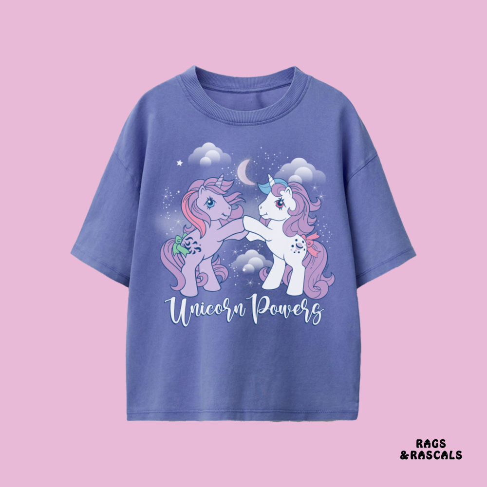 Blue t-shirt with unicorn design and 'Unicorn Powers' text on a pink background, featuring the brand 'Rags & Rascals'.