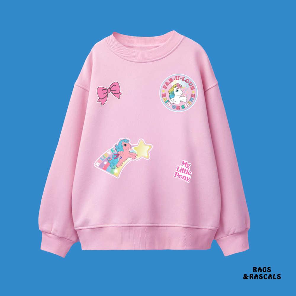 Pink sweatshirt with colorful patches pony and stickers, from a children's brand called "Rags and Rascals".