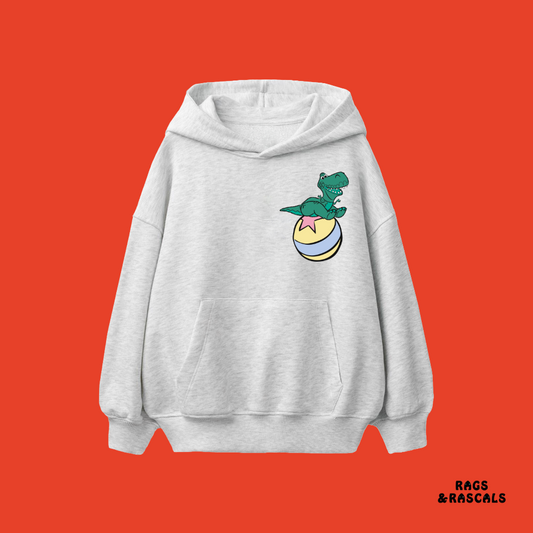 Light grey hoodie with a dinosaur sitting on a ball graphic, from a children's brand called "Rags and Rascals".