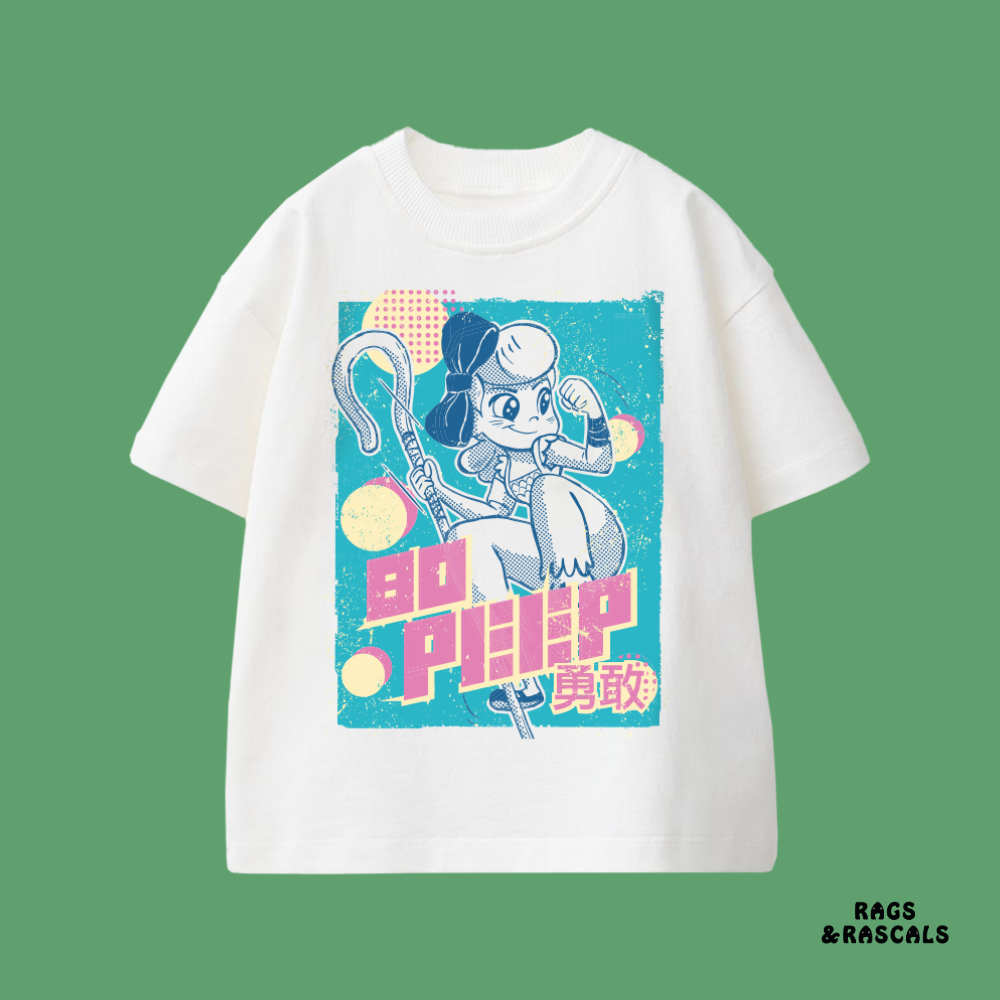 White t-shirt with a graphic design of a character and text,  from a brand called "Rags and Rascals". 